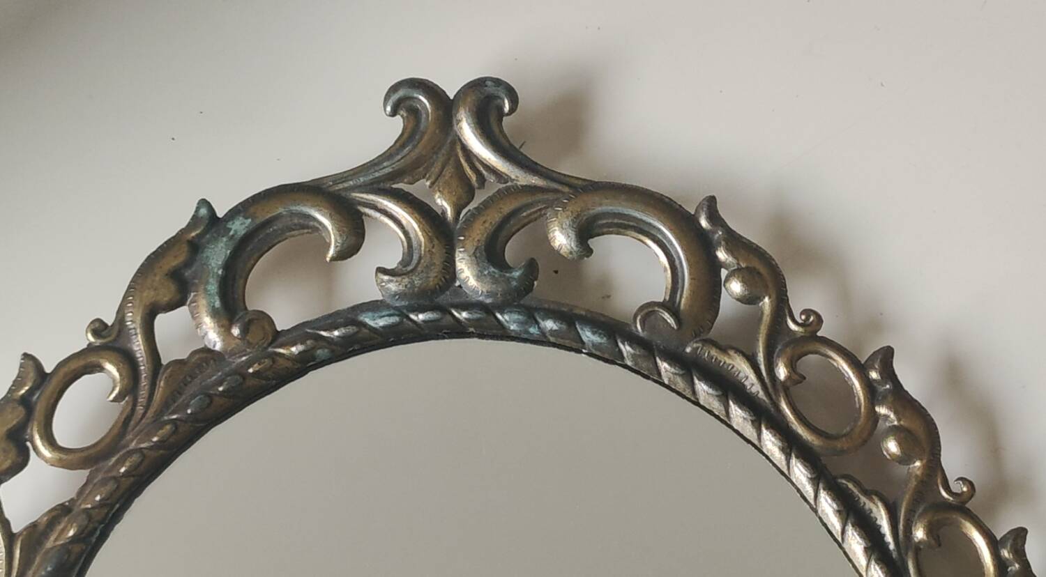Antique oval mirror in Baroque/Rococo style. Made of gilded spelter. Dimensions: 42 x 31 cm