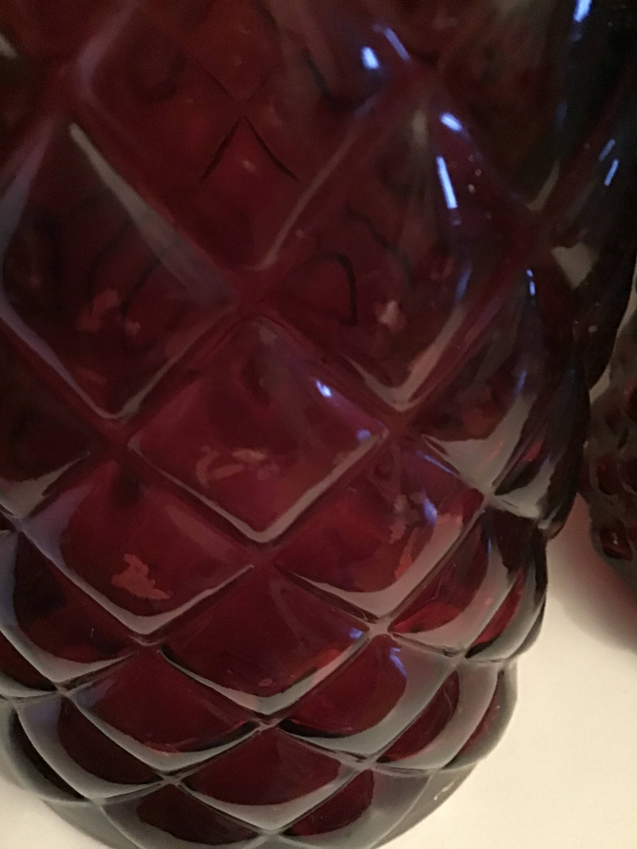 2 red molded glass bottles or jars