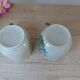 Set of two speckled stoneware mugs with small wildflower bohemian retro design.