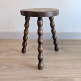 Small wooden tripod stool with turned legs, country style.