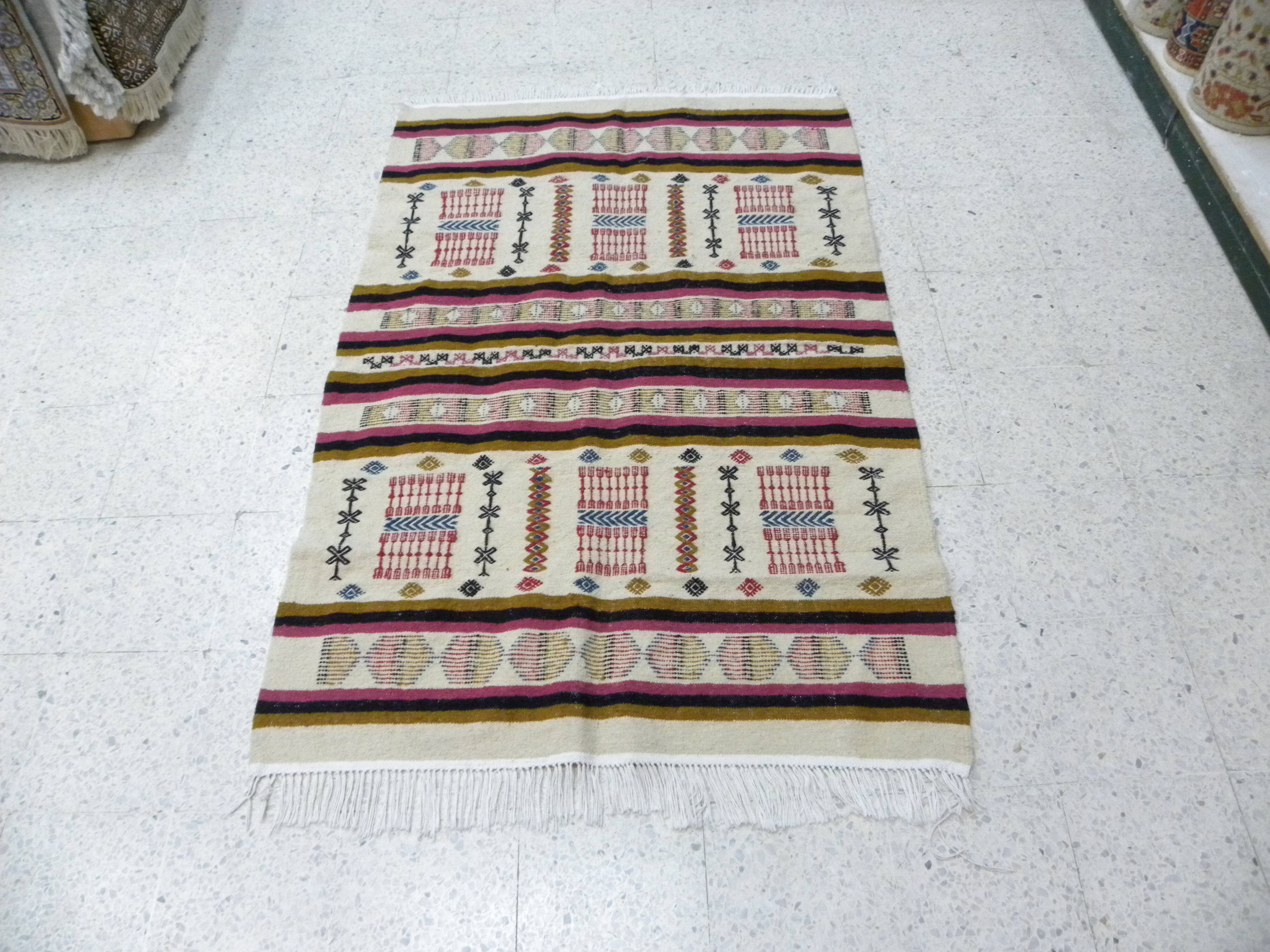Handmade Berber kilim rug with multicoloured tribal motifs.
