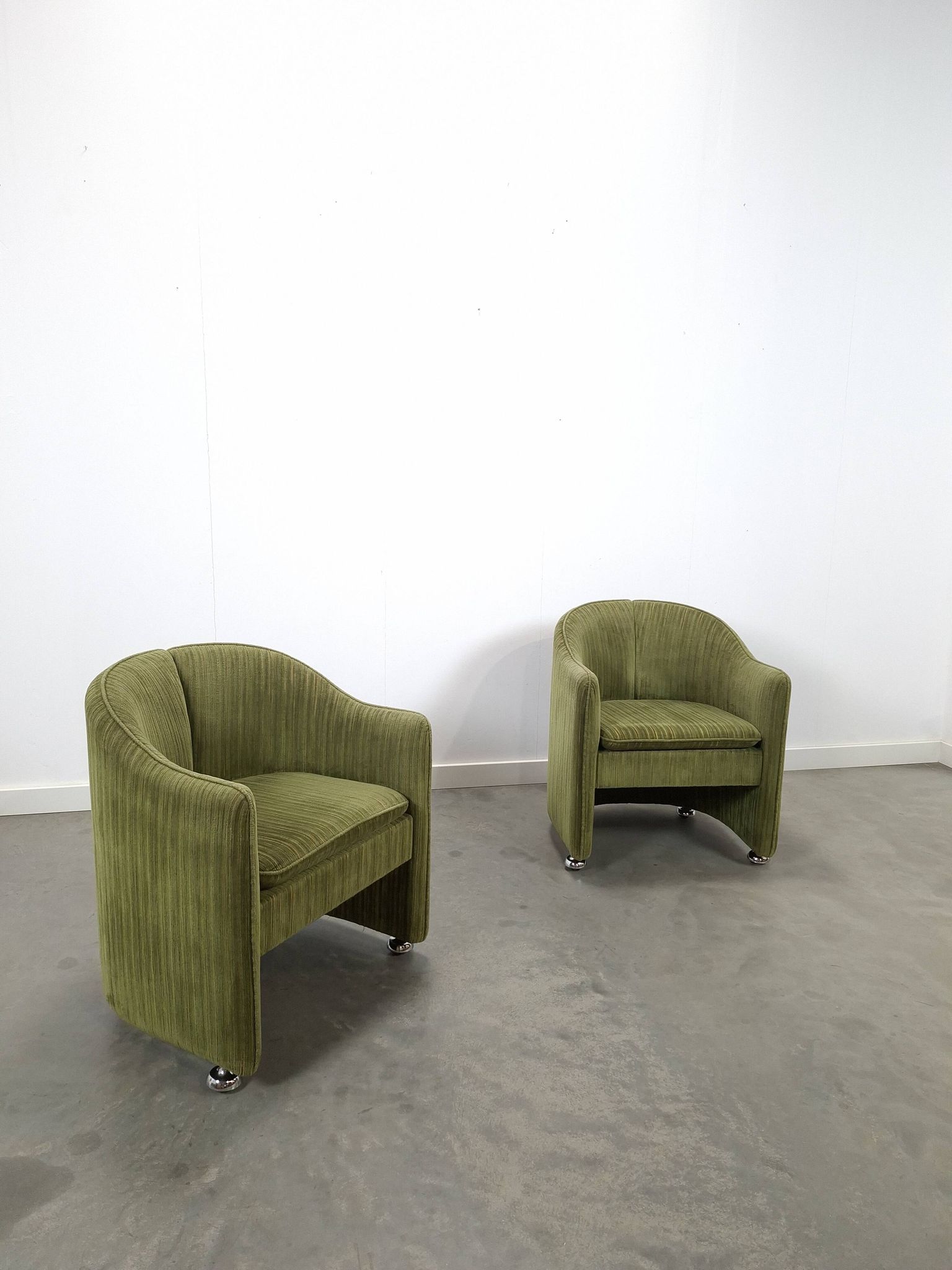 Chaises de cocktail vertes avec des roues chromées.