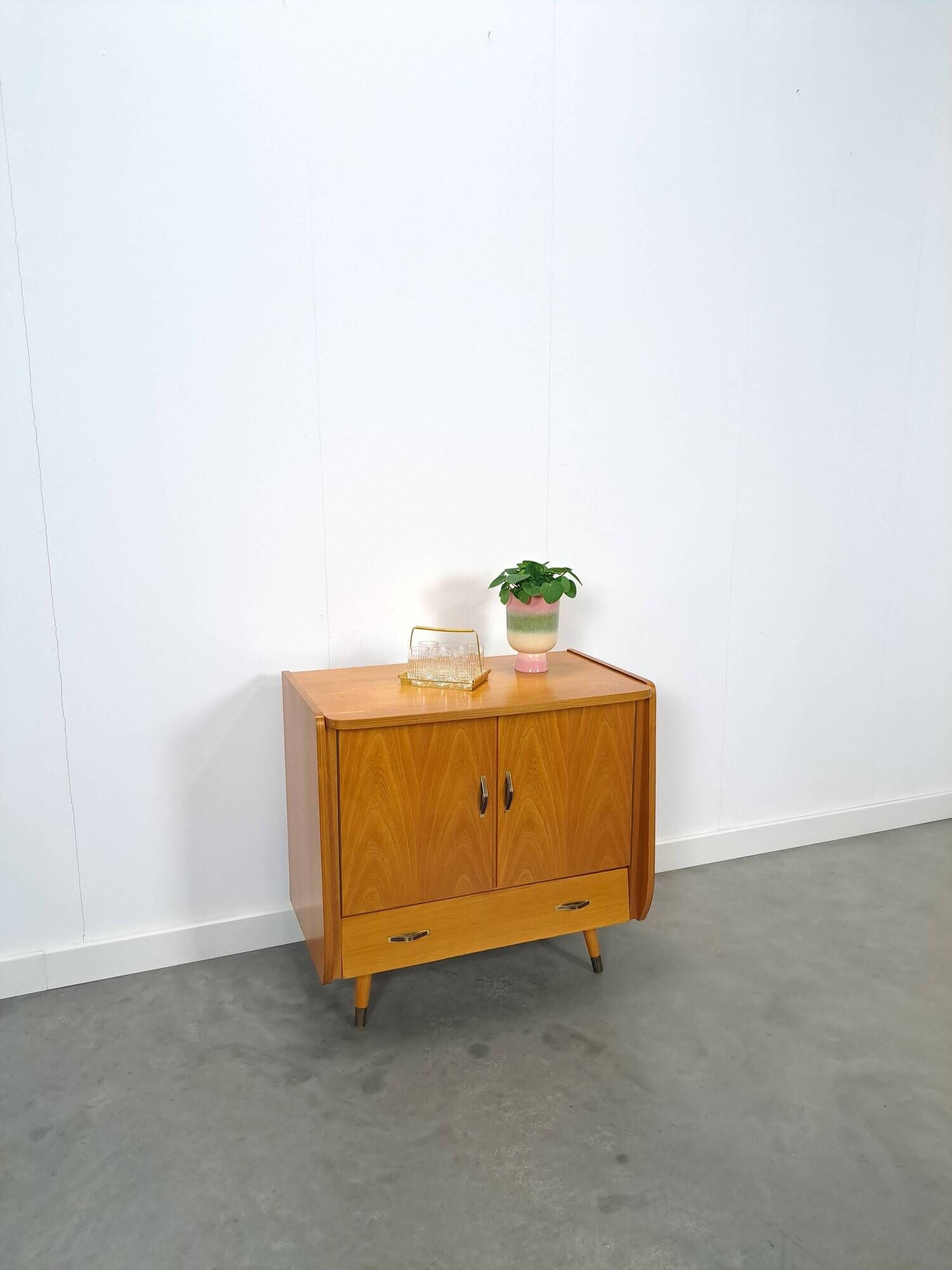 Meuble TV audio avec poignées en laiton et pieds inclinés.