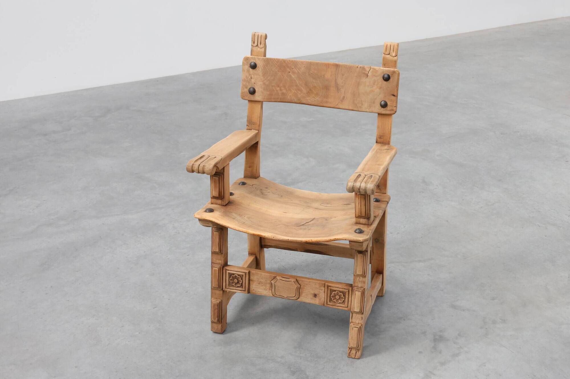 Brutalist armchair with carved rosettes and nailed wooden seat, Spain