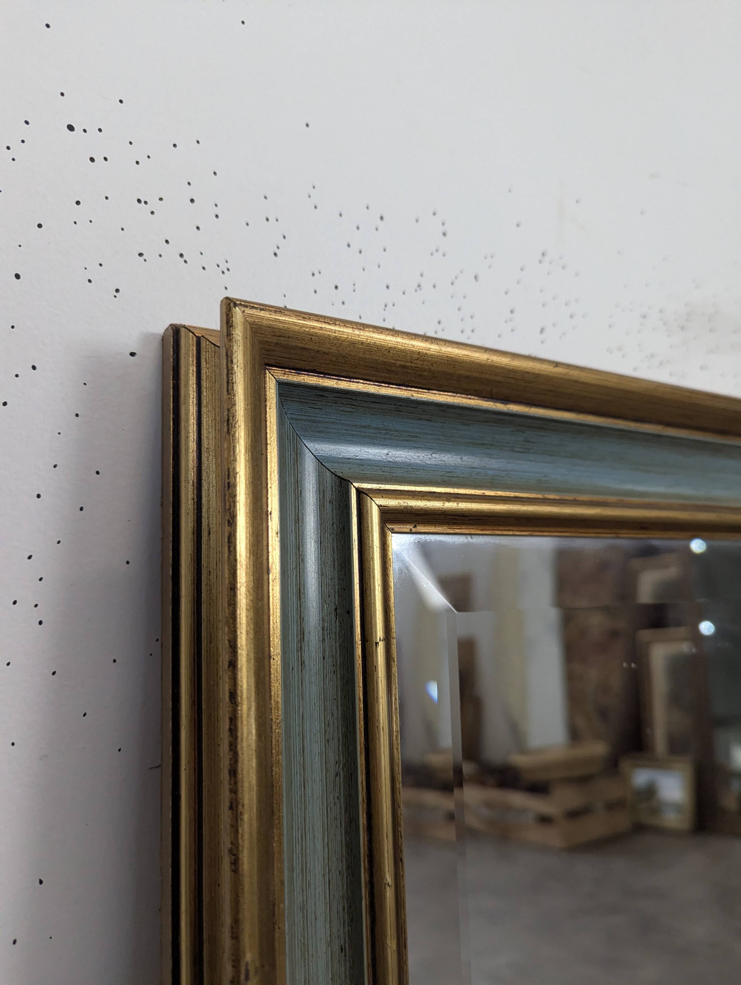 Rectangular mirror with a green and gold lacquered frame.