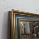 Rectangular mirror with a green and gold lacquered frame.