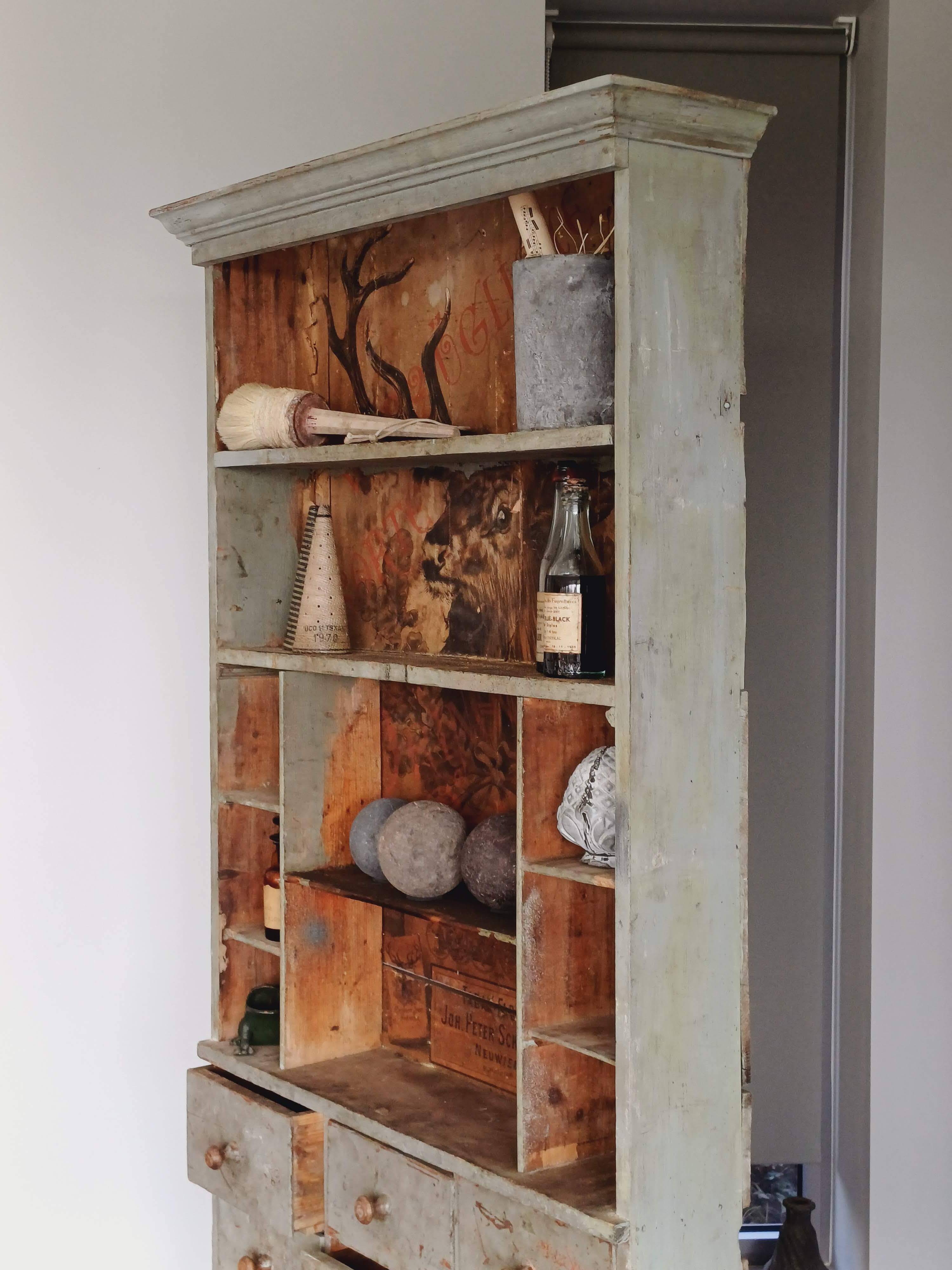 Craft cabinet with drawers with a very old tobacco advertisement in the background