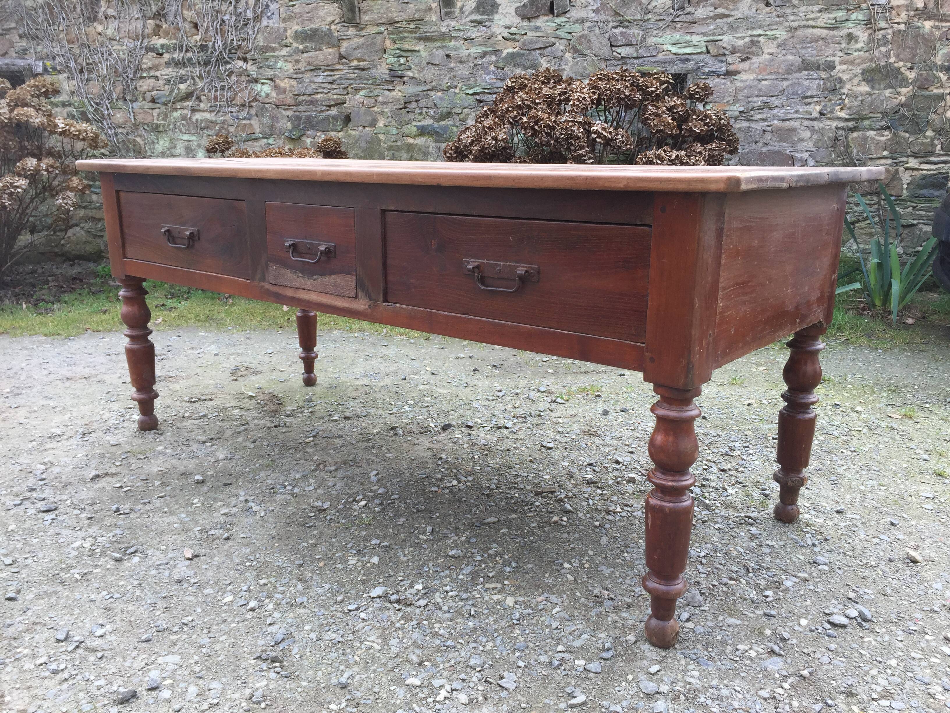 Old farmhouse table with cherry and chestnut panels with 3 drawers.
