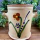 Antique ceramic pot with hand-painted floral decoration.