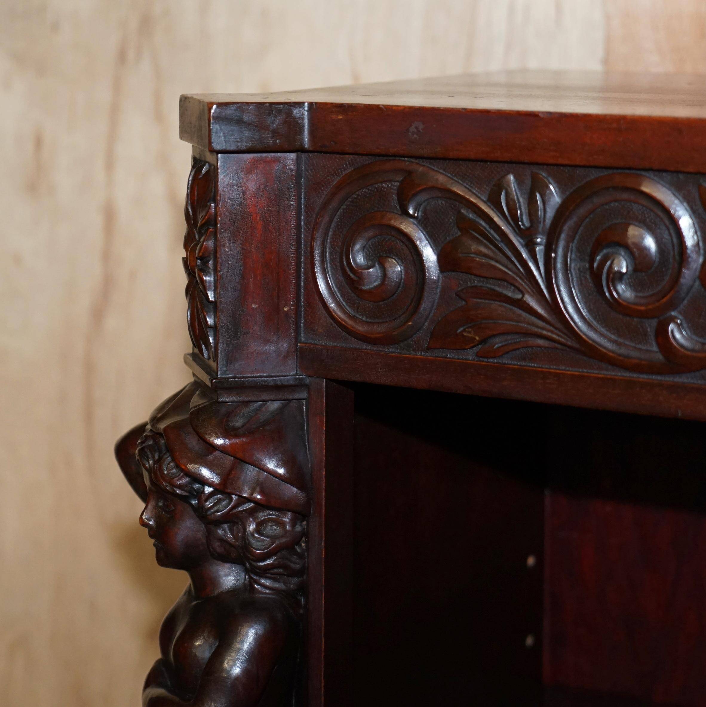 Hand-carved library circa 1900 in hardwood with Hermes statues.