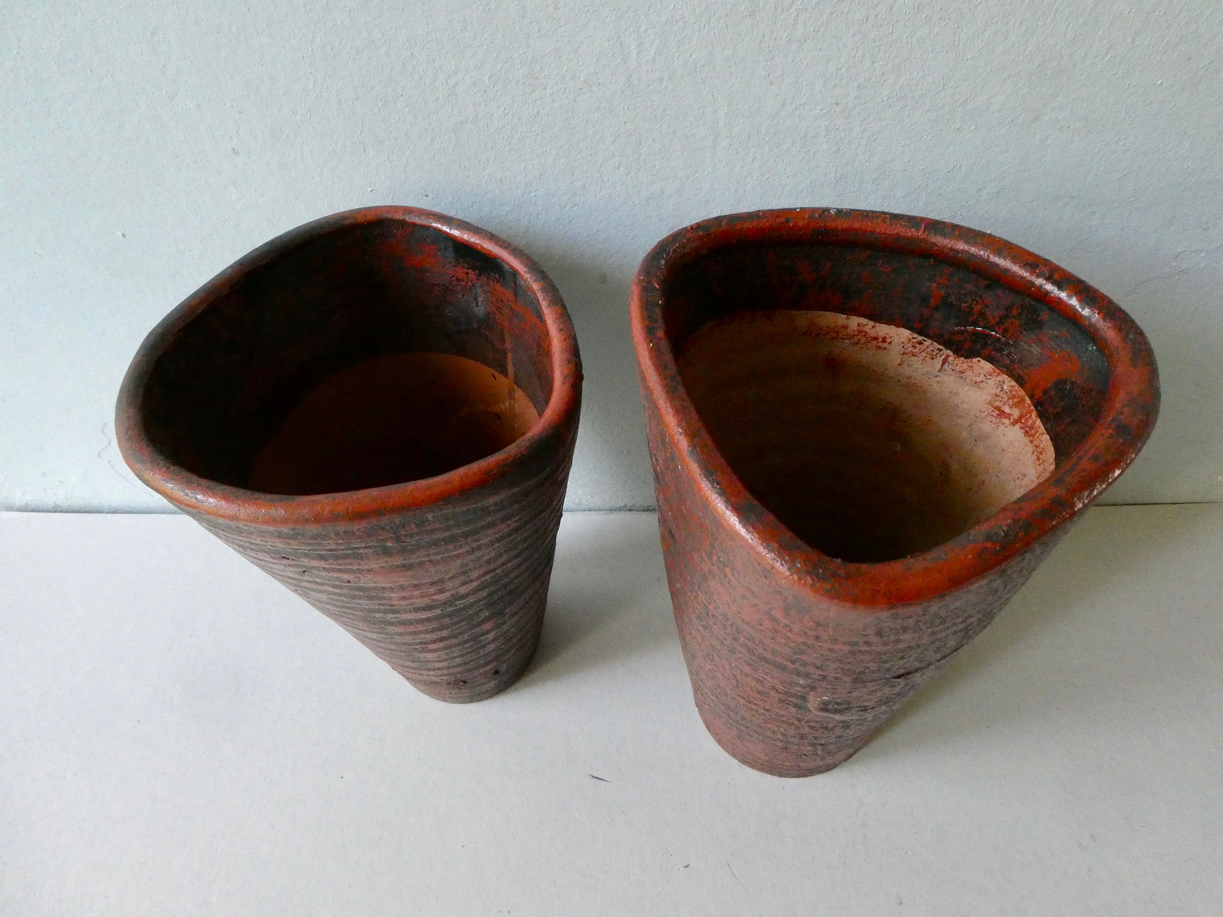 Pair of red enamelled terracotta vases, signed