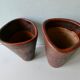 Pair of red enamelled terracotta vases, signed