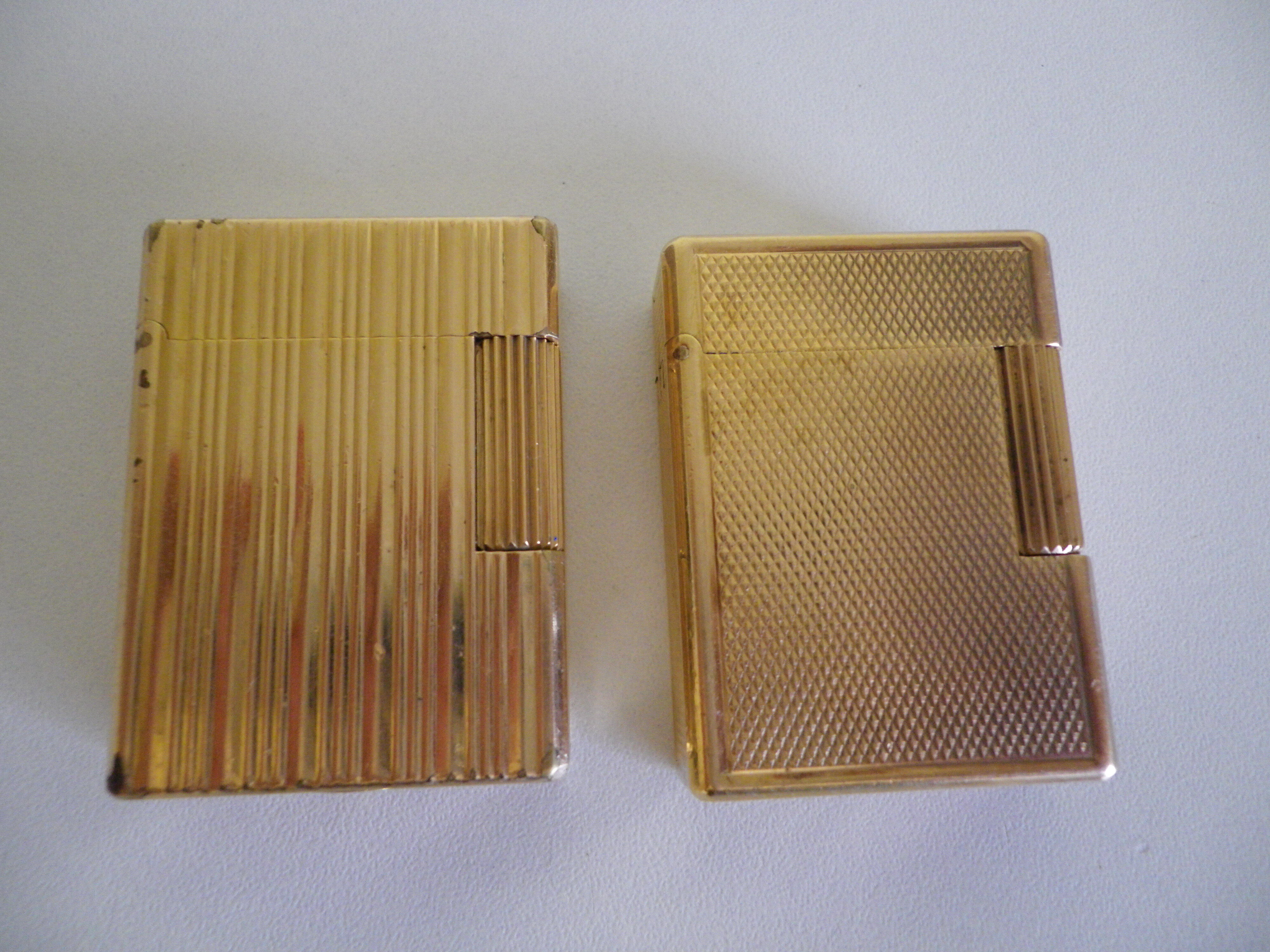 2 st dupont lighters, gold plated, punches, numbered, 1 striated pattern, 1 hammered pattern, 70s