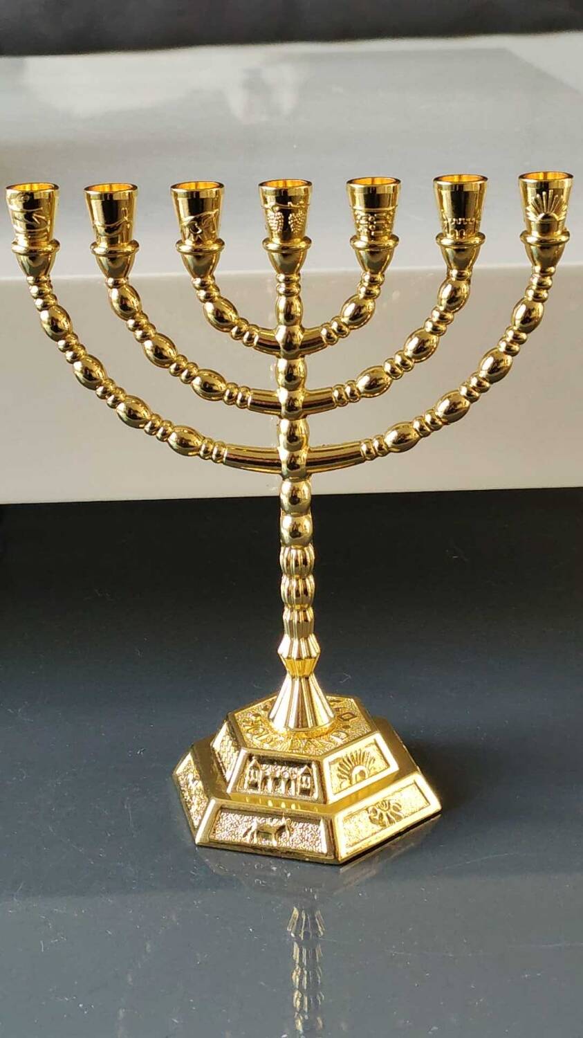 Menorah/Jewish/Hebrew candlestick with 7 arms of light. Engraved with the symbols of the 12 tribes of Israel/Holyland inscription. In gold metal. Size 20 x 16 cm