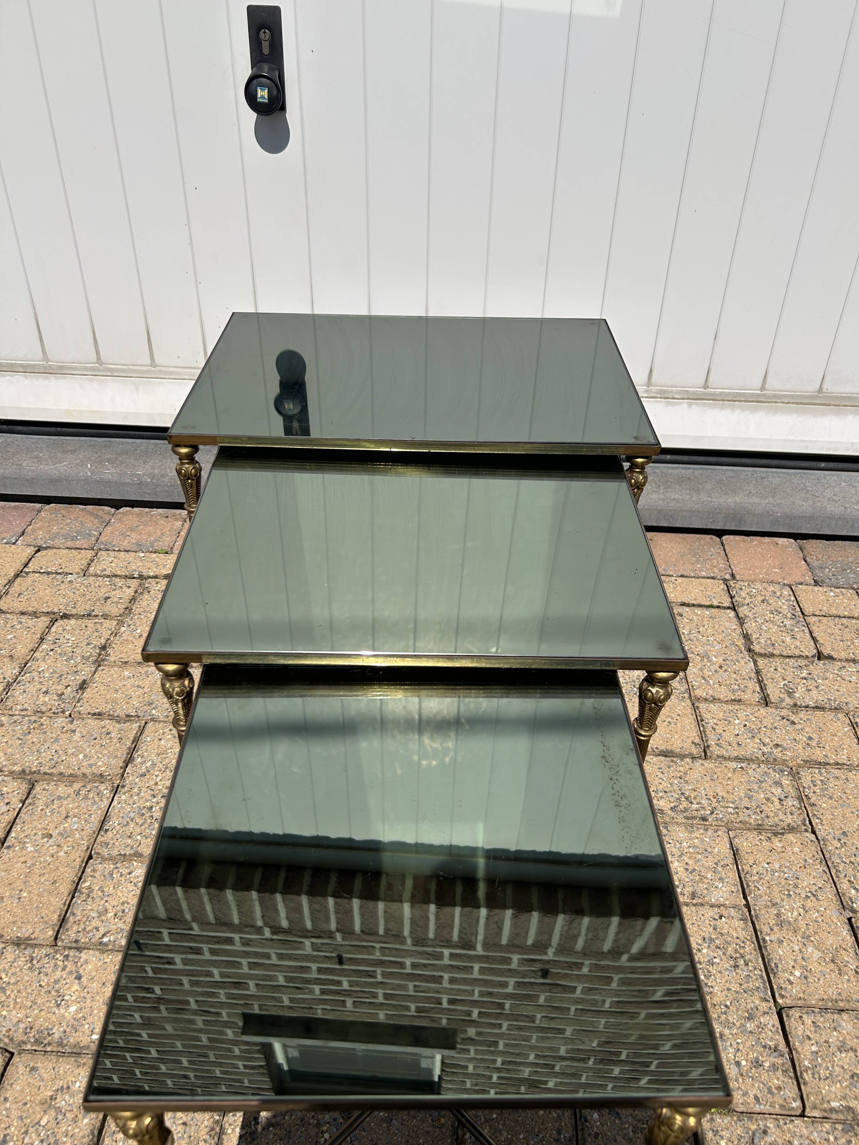 Nested tables in gilded brass in the style of Maison Charles.