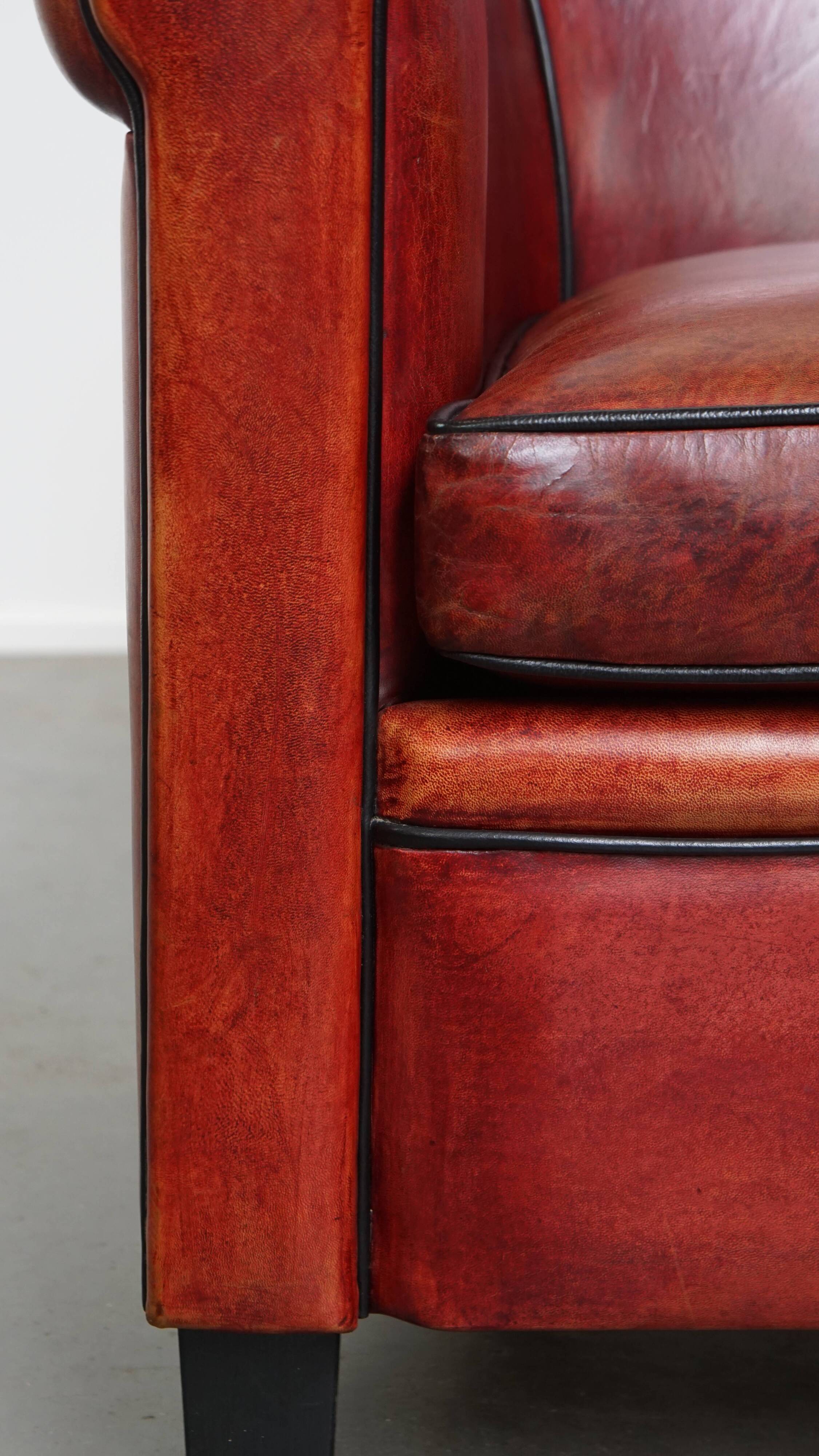 Armchair made of sheepskin leather in a red/brown color