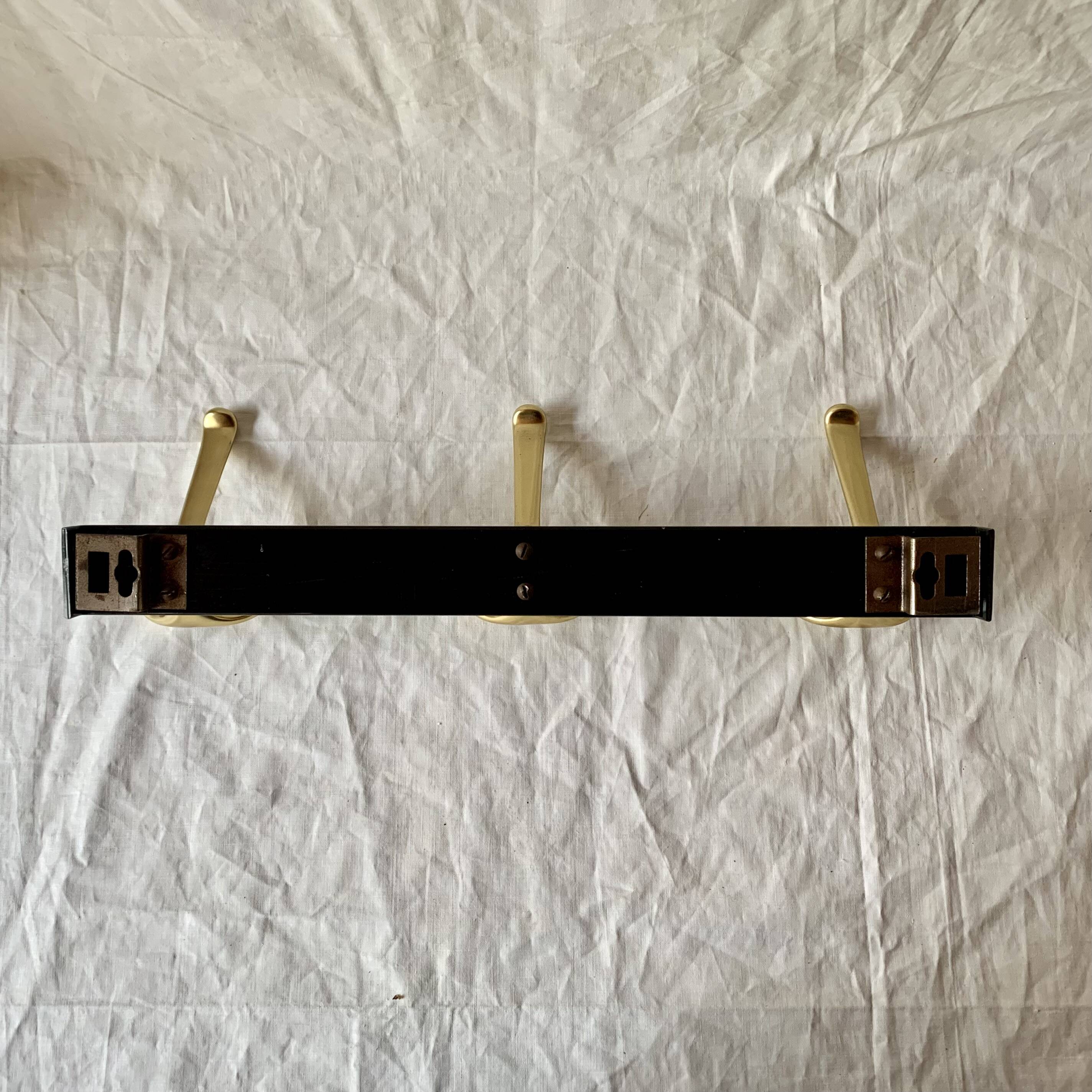 Vintage coat rack in lacquered metal with three golden aluminum hooks