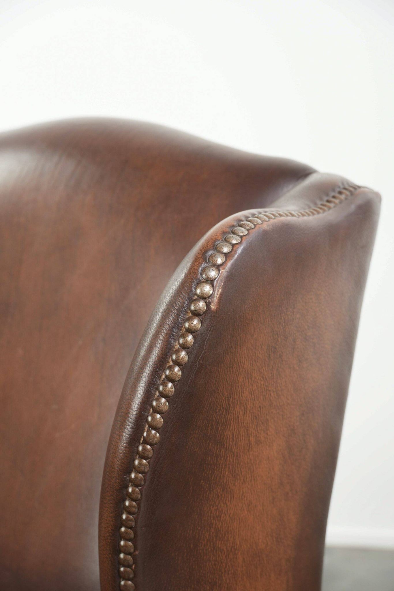 Ensemble de 2 fauteuils à oreilles en cuir de vache de style anglais.