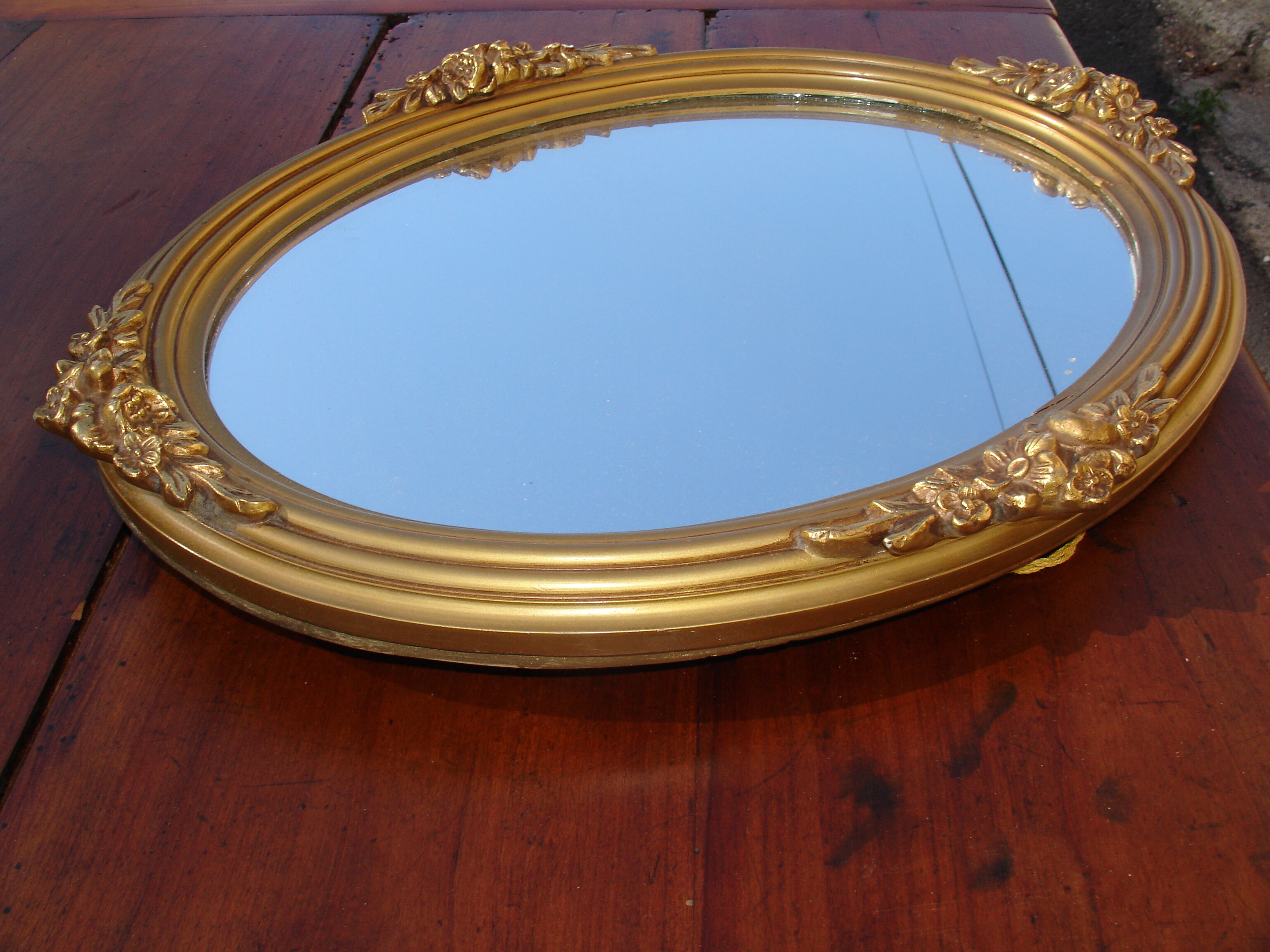 Oval gilt mirror, 30 x 44 cm, with floral decoration, circa 1930