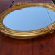 Oval gilt mirror, 30 x 44 cm, with floral decoration, circa 1930