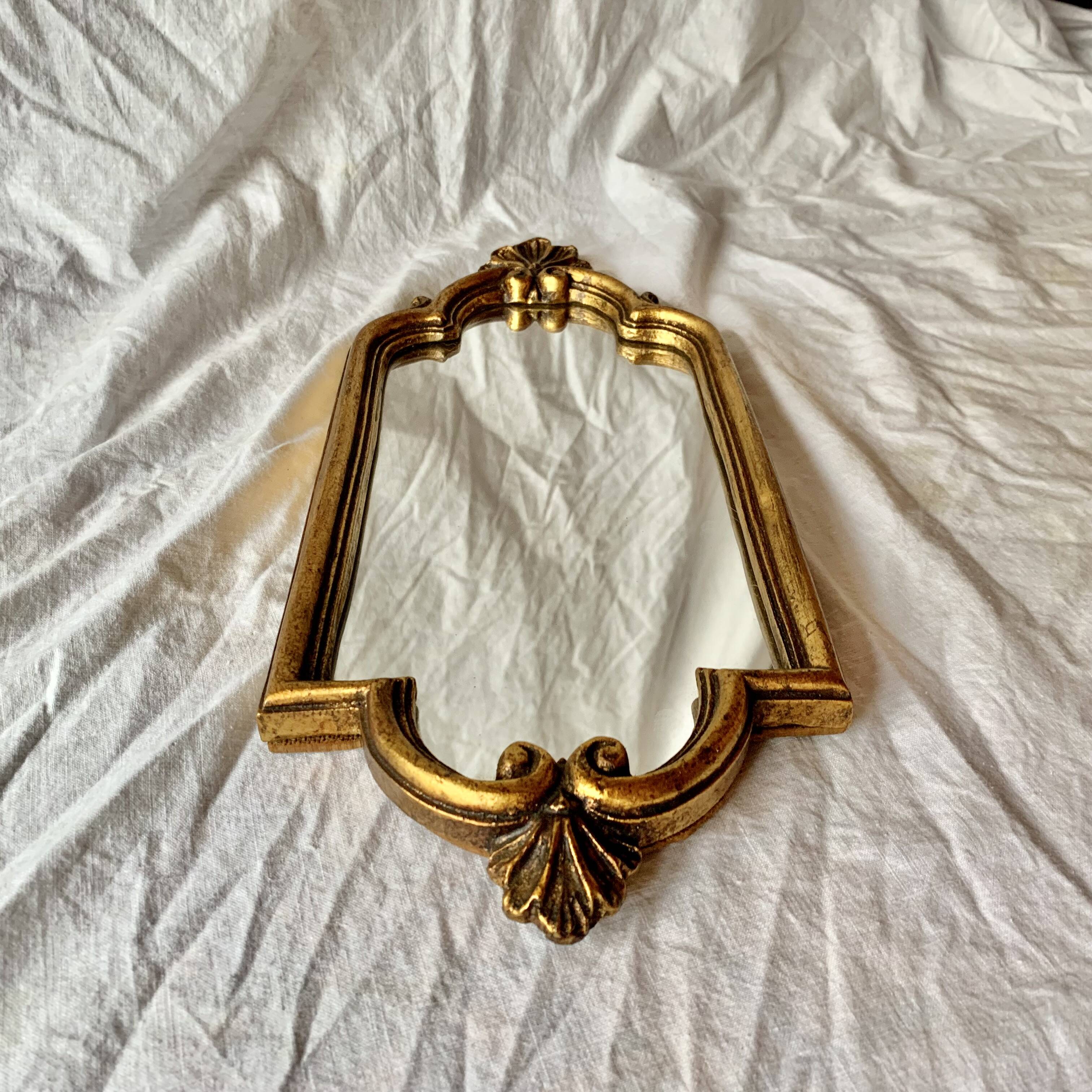 Old small wall mirror in golden resin