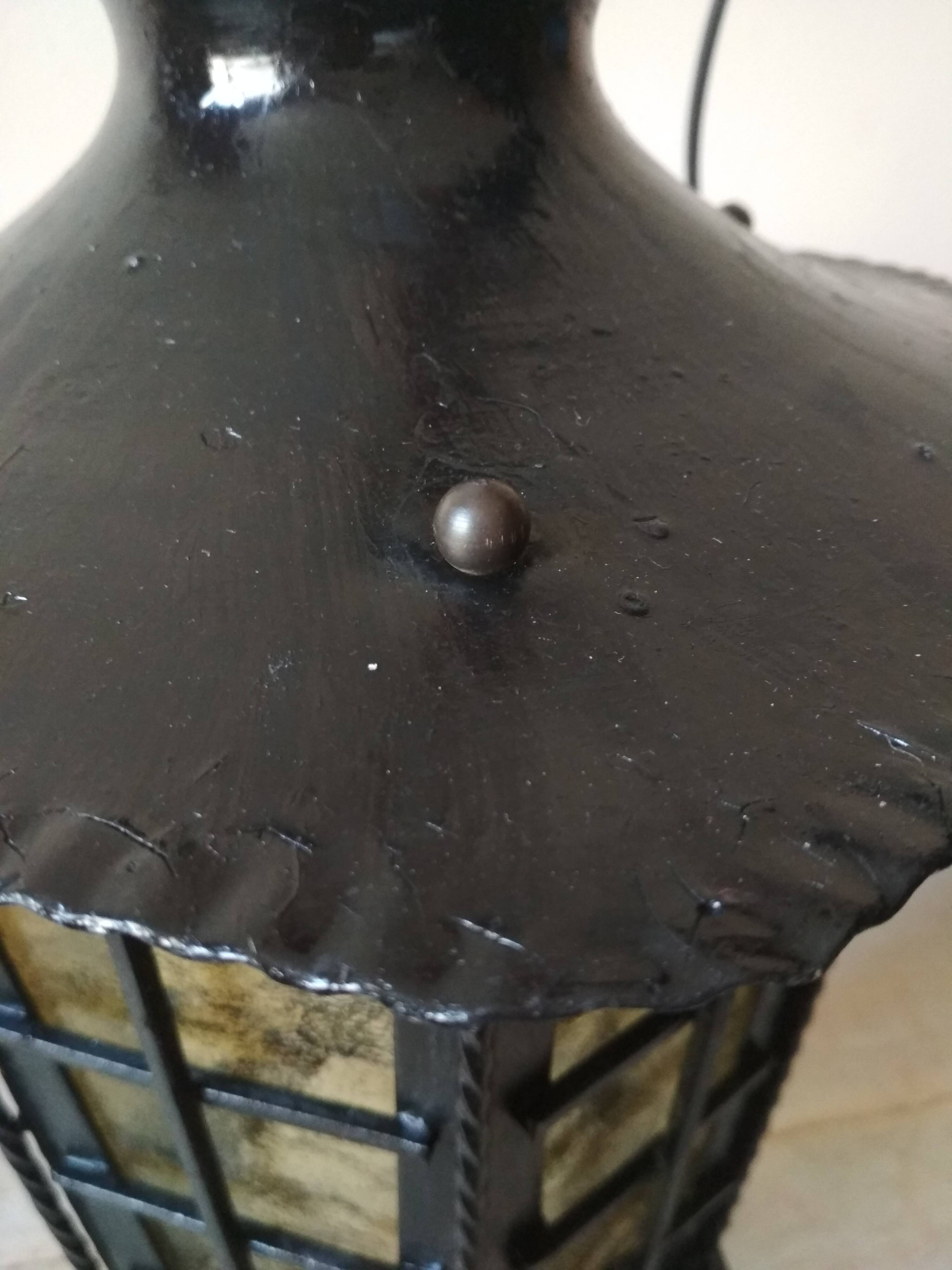 Large hanging lantern in wrought iron and opaque yellow-orange windows