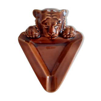 Brown ashtray with lion's head.