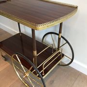 Mahogany and brass rolling table in the style of Maison Jansen.