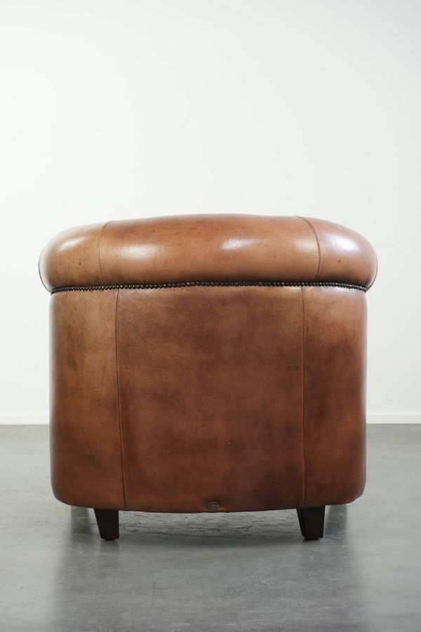 Fauteuil club en peau de mouton vintage de style anglais avec des couleurs profondes.