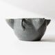 Vintage ceramic ashtray from the 1960s, black, hand-sculpted texture, organic shape.