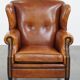 Sheepskin wingback armchair with stitching and black piping