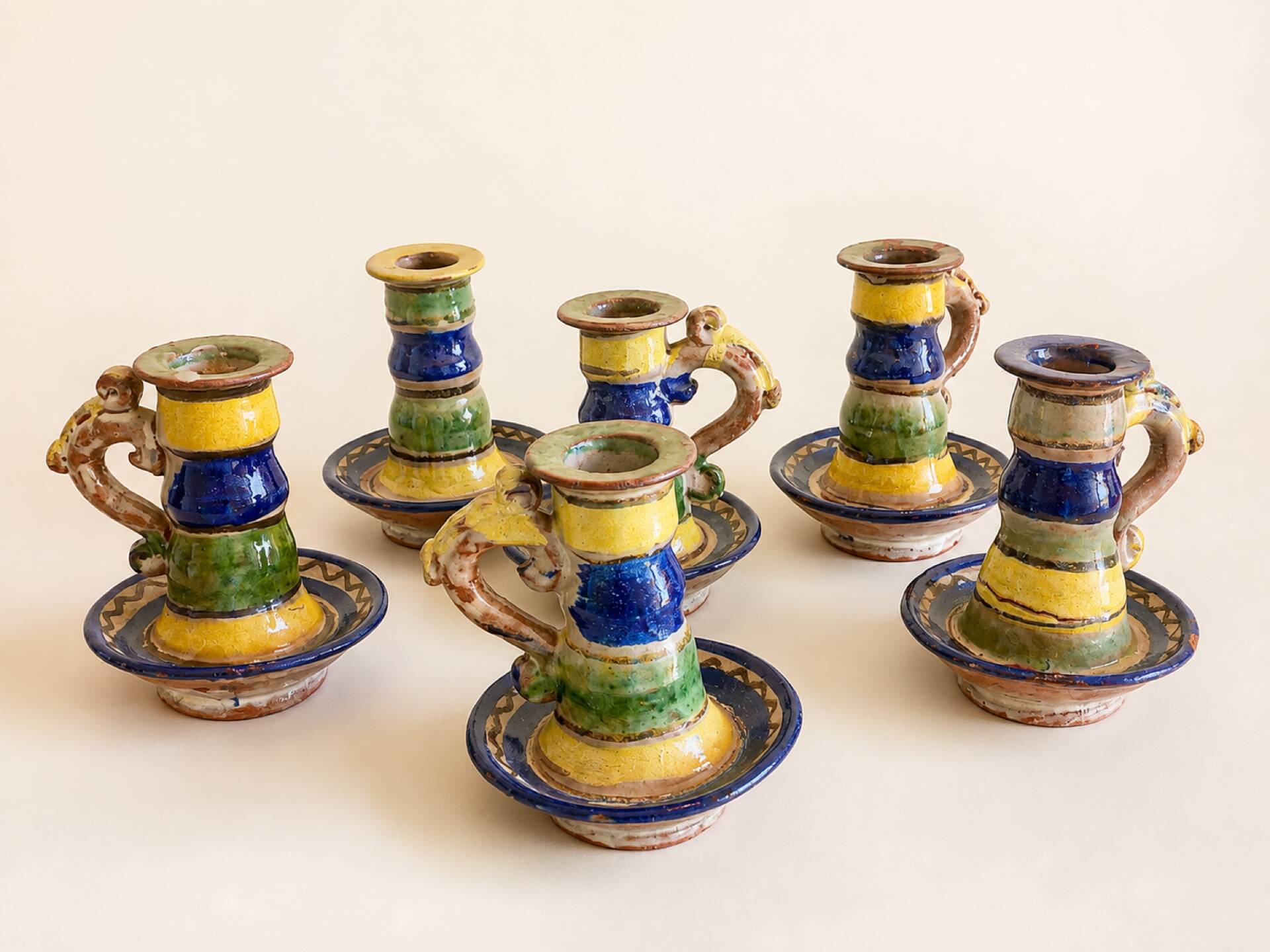 Many old glazed terracotta candlesticks.