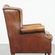 Cognac-colored sheep leather wingback chair finished with black piping