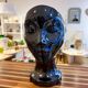 Black ceramic vase with a woman's face.