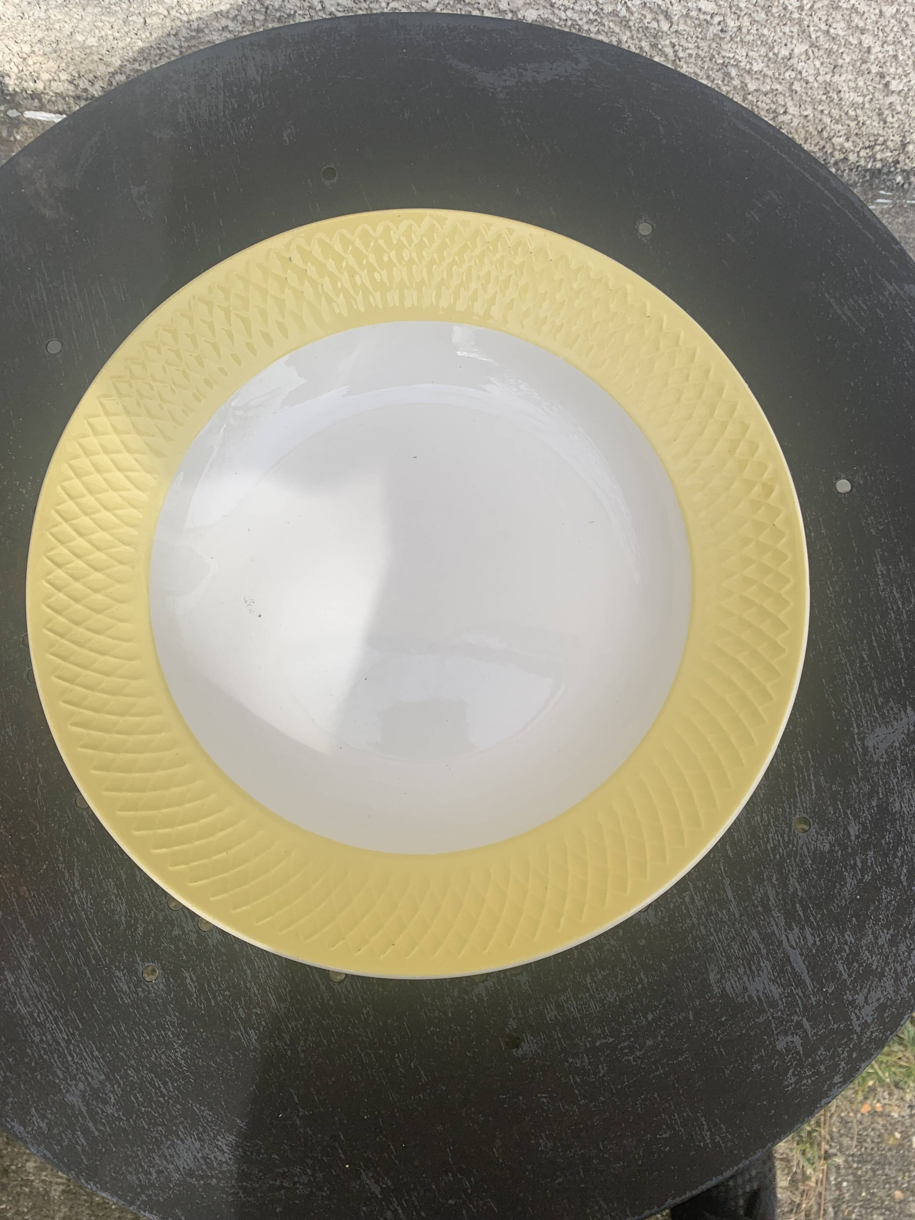 Two earthenware dishes, one hollow and one white cake dish with yellow border
