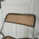 Vintage folding chair in metal and cane.