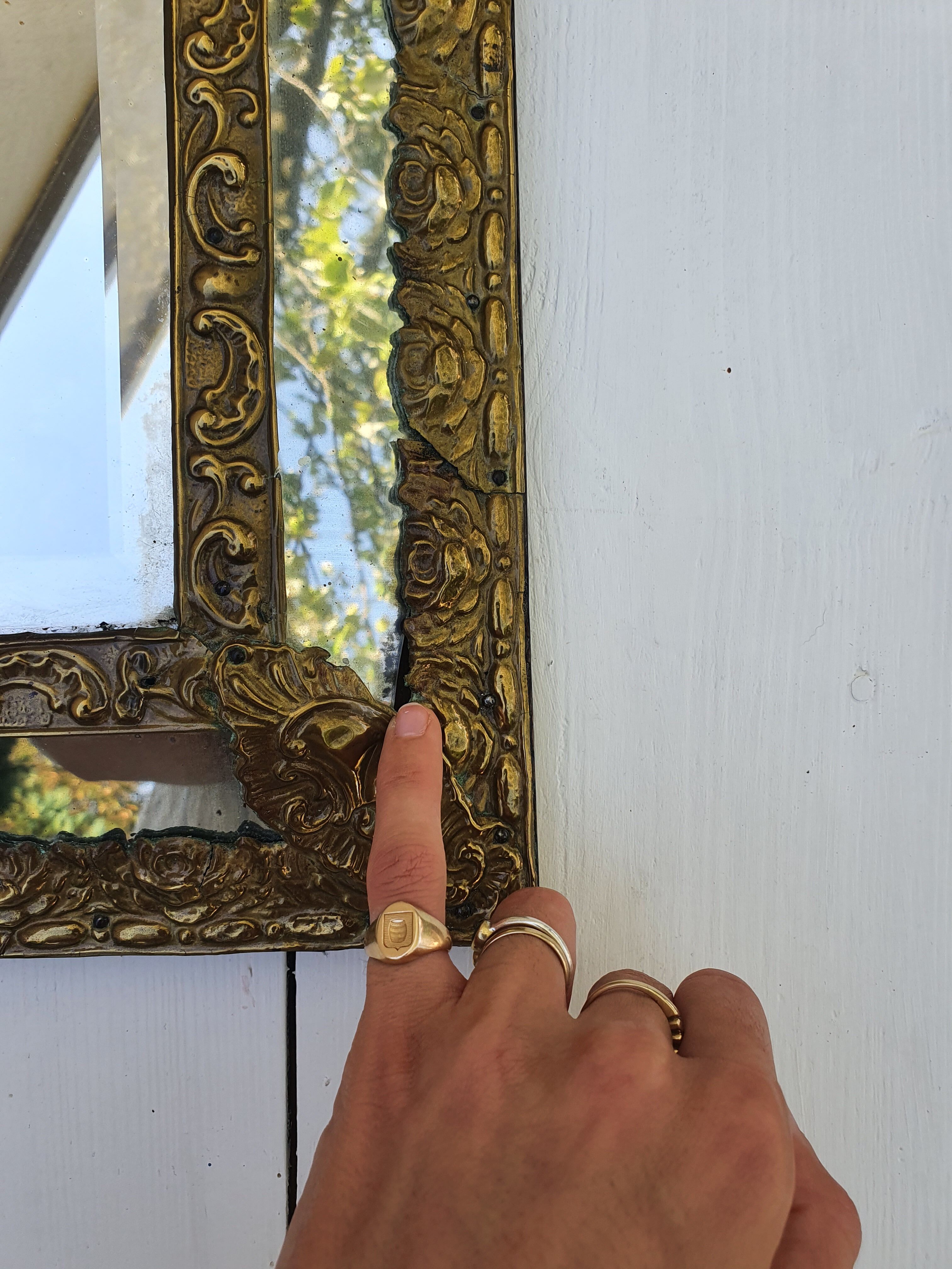 Miroir à parecloses en bois doré et métal repoussé
