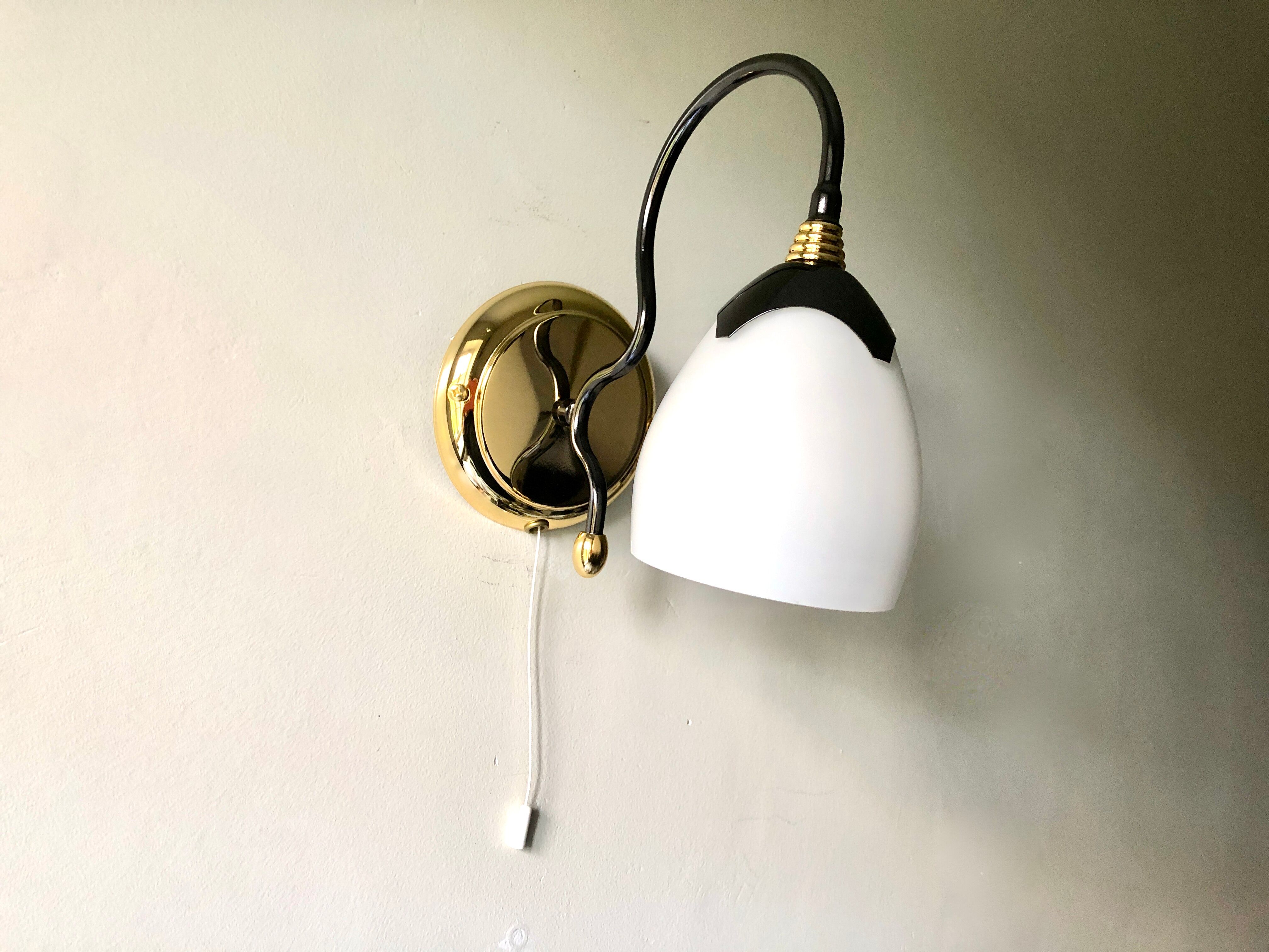 Black and gold wall light with white opaline flower, Italy 1990.
