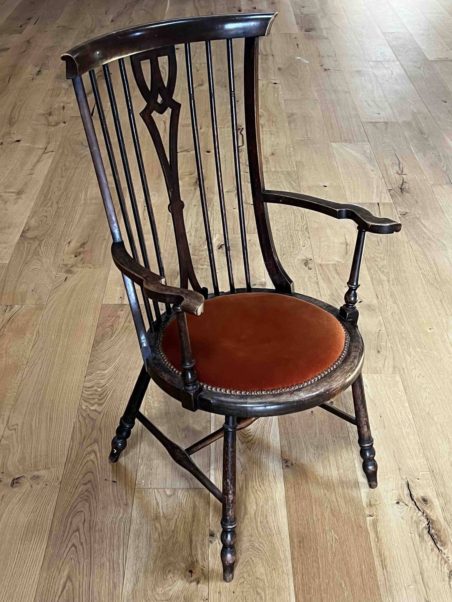 Windsor chair with comb back, stained wood and terracotta velvet.