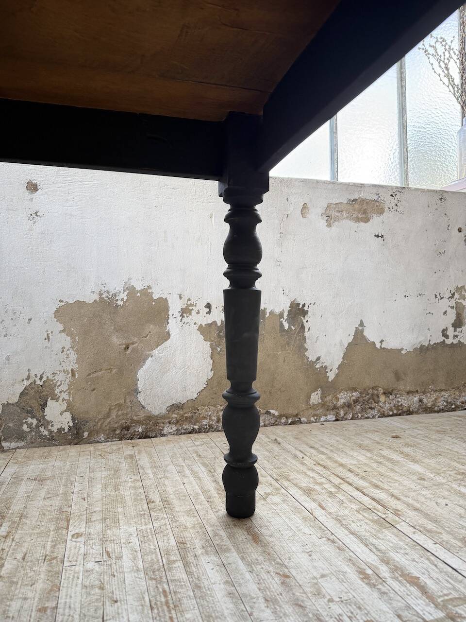 Oak farmhouse table with turned black legs.