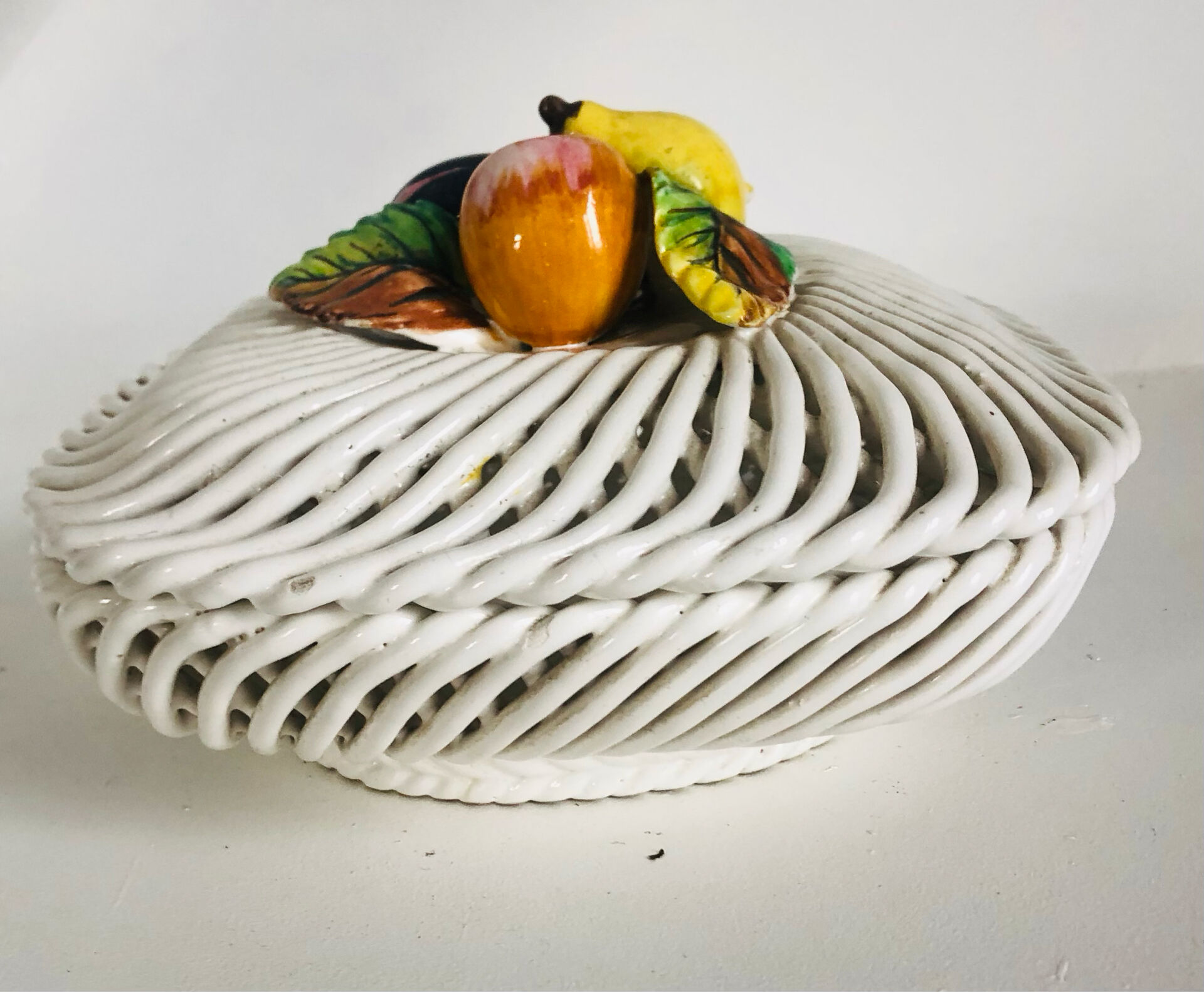 Covered basket in white woven ceramic and fruit slip.