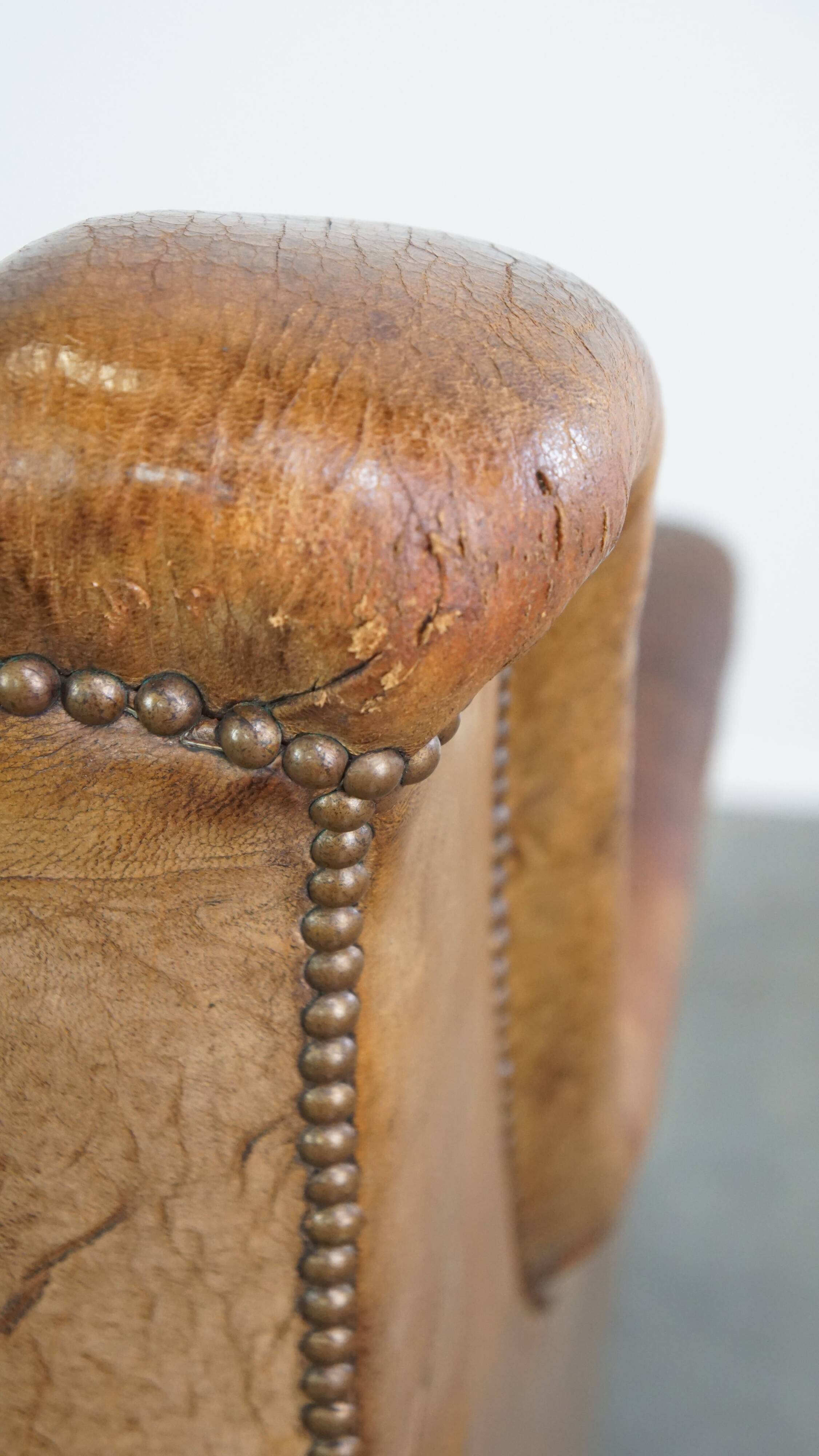 Fauteuil en cuir de mouton antique caractéristique avec de beaux détails et un design unique
