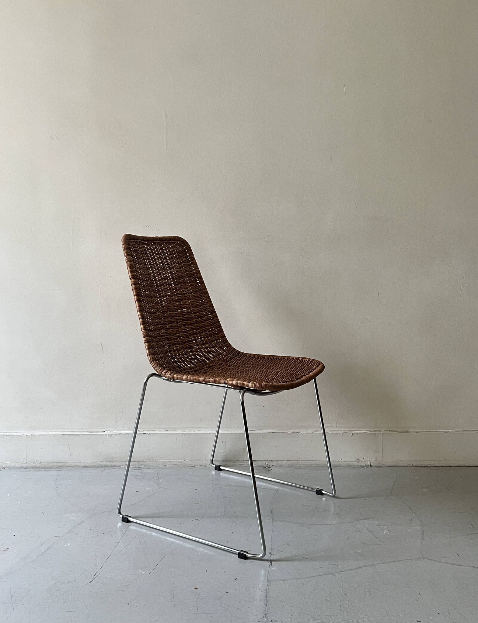 Chair design in rattan, woven wicker and chrome wire metal.