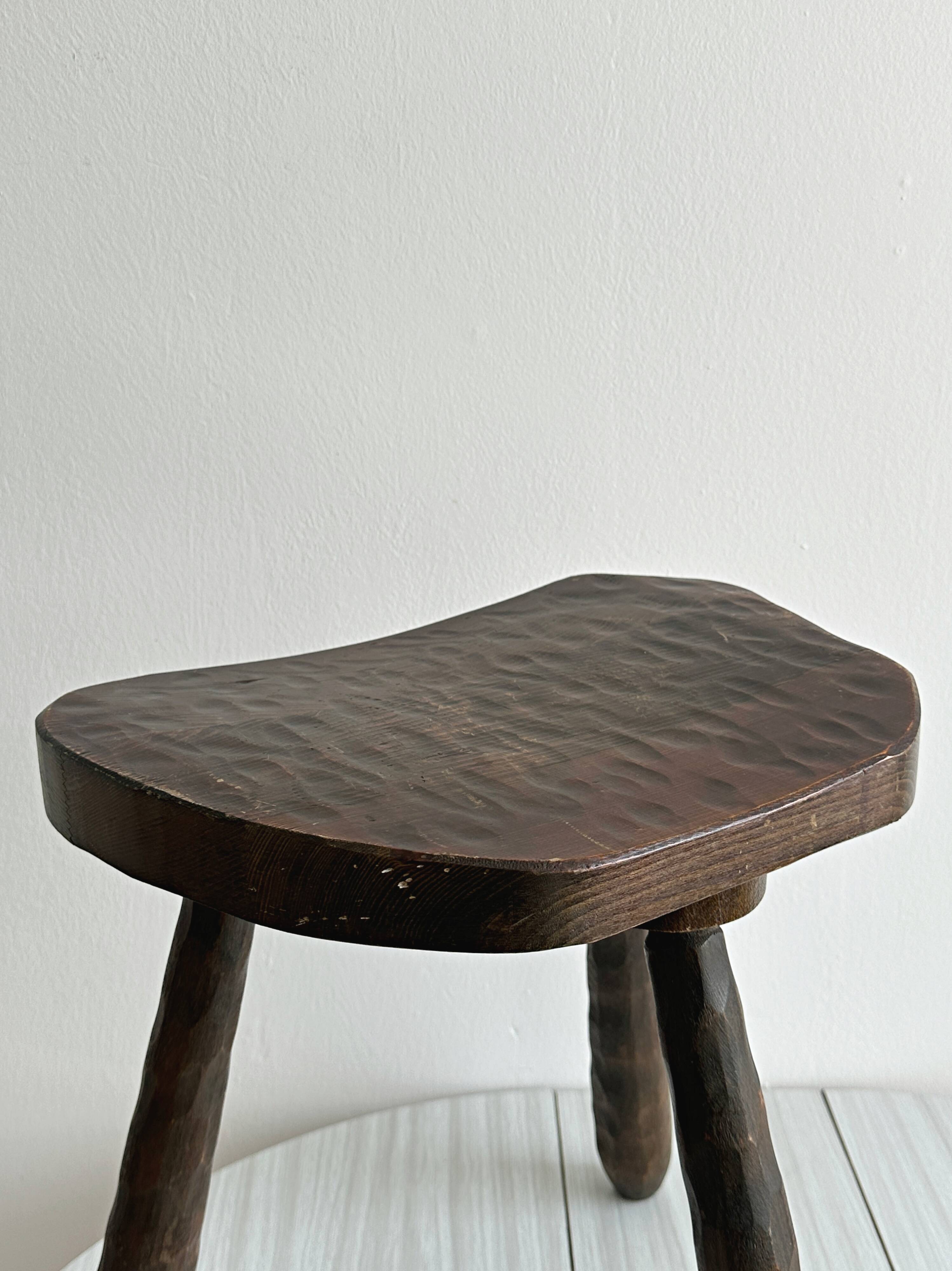 Tabouret tripode ancien en bois foncé sculpté