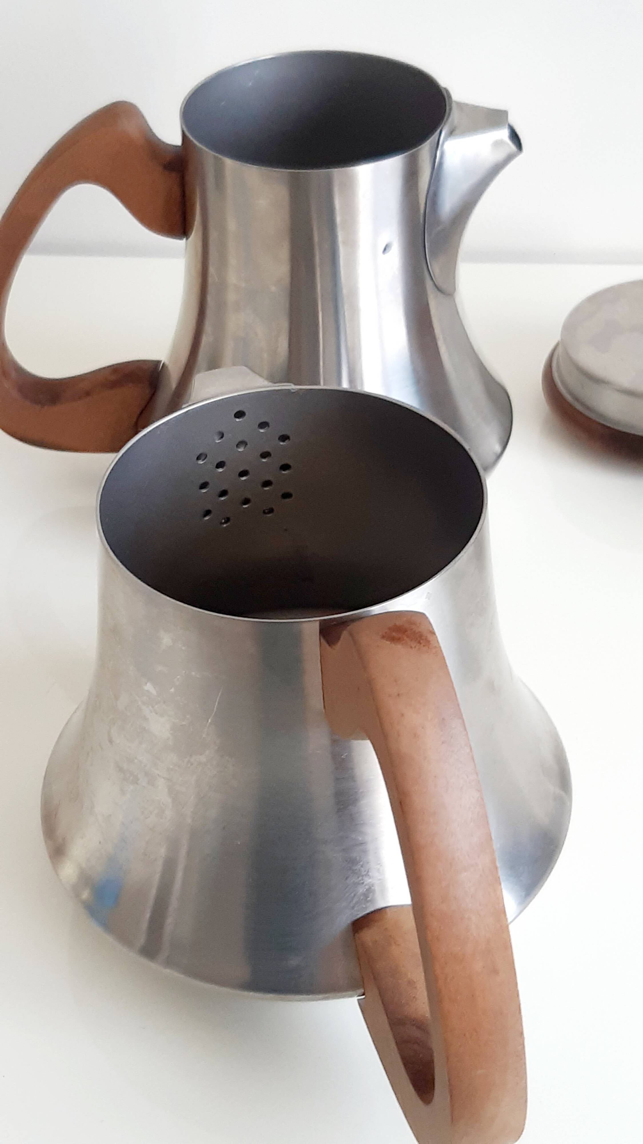 Letang and Remy tea and coffee service in plain stainless steel, exotic wood handles and lids.