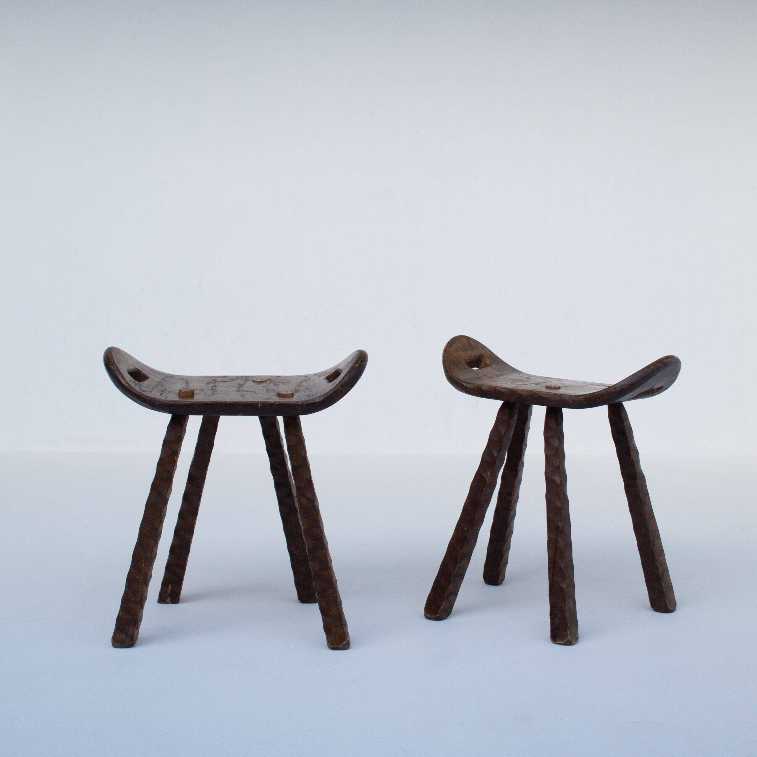 Ensemble de deux tabourets en bois sculptés à la main avec poignées.