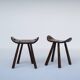 Ensemble de deux tabourets en bois sculptés à la main avec poignées.