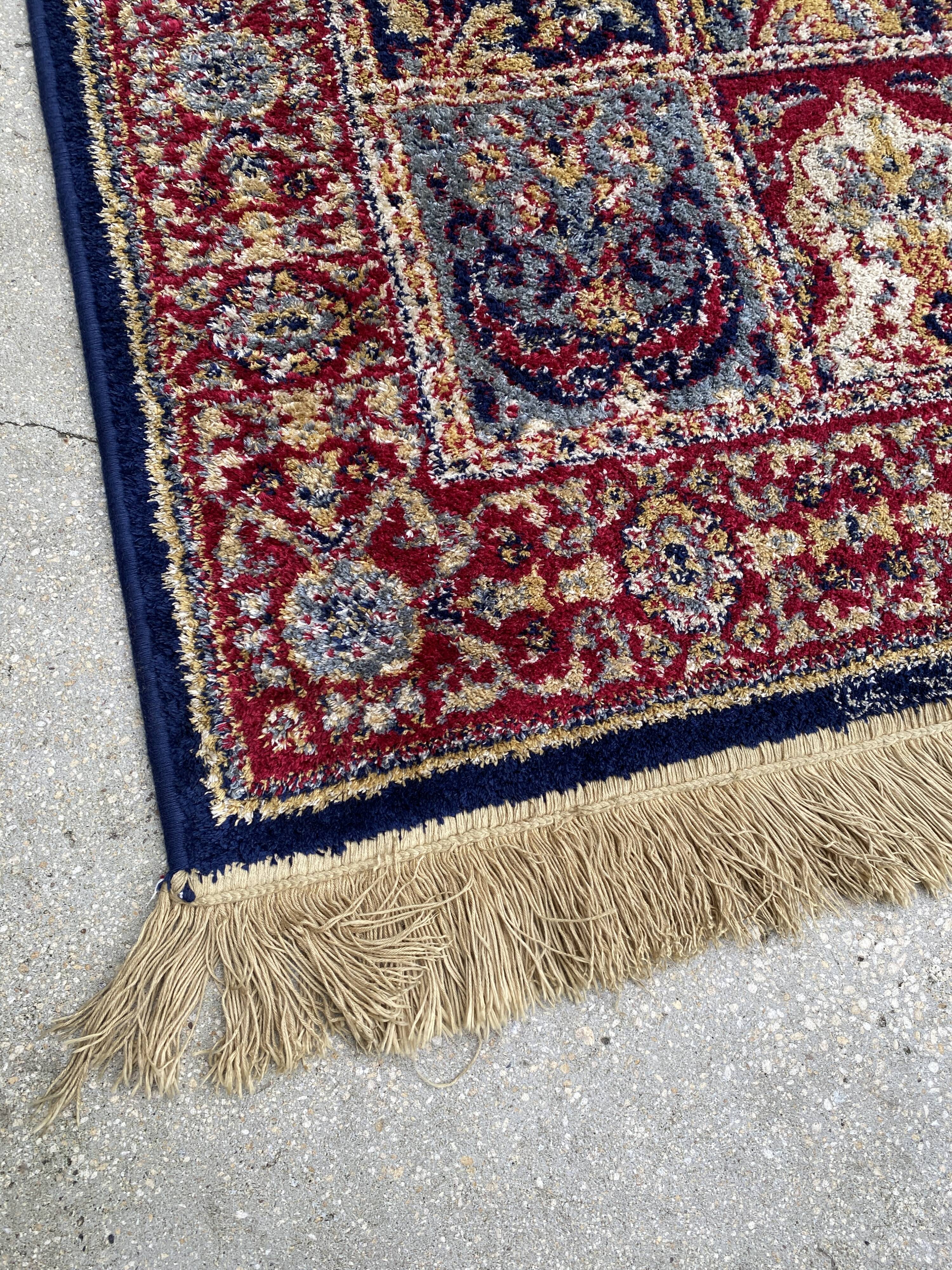 Vintage mechanical Turkish rug with box decoration on a red and navy blue background 139 x 68 cm