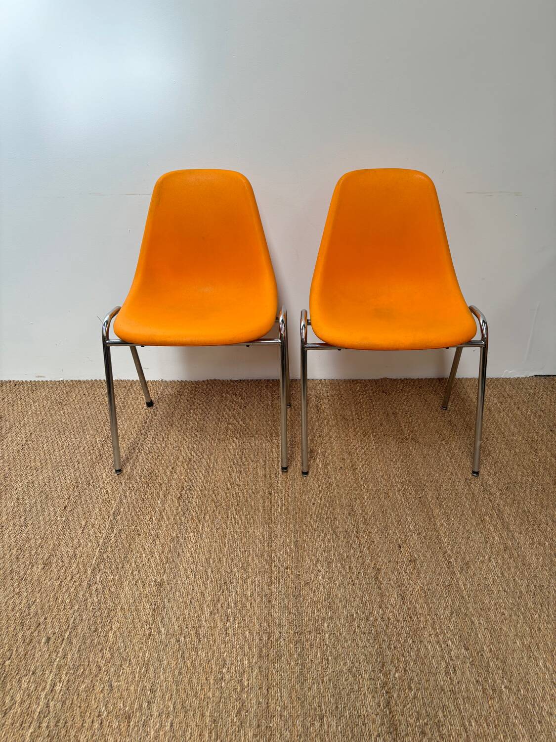 Two orange plastic pollak chairs at Orly airport