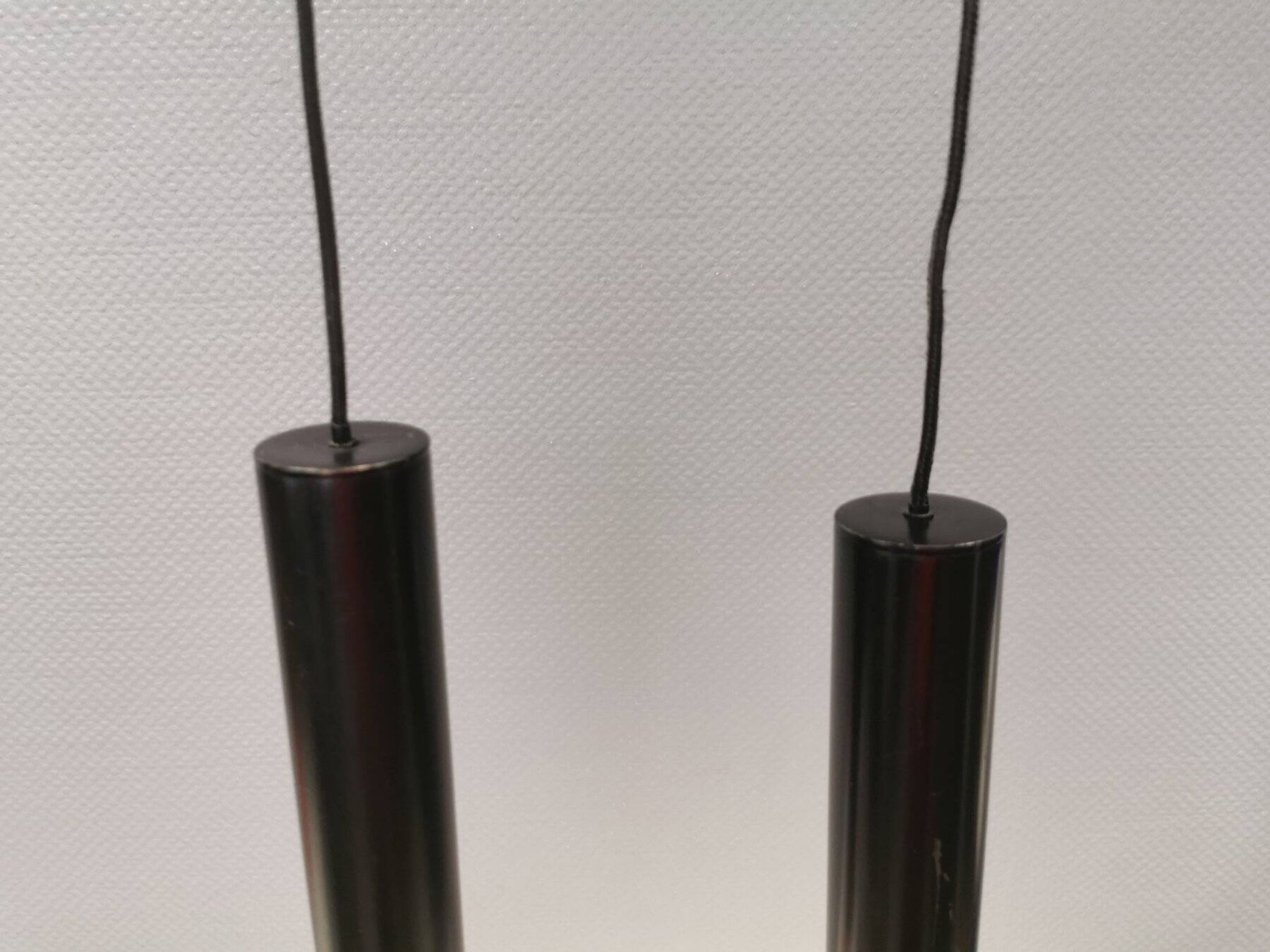 Two cylinder-shaped hanging lamps in black lacquer